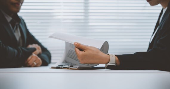 Business partners engaged in reviewing contract terms during an office meeting, emphasizing negotiation and reaching an agreement on key business matters